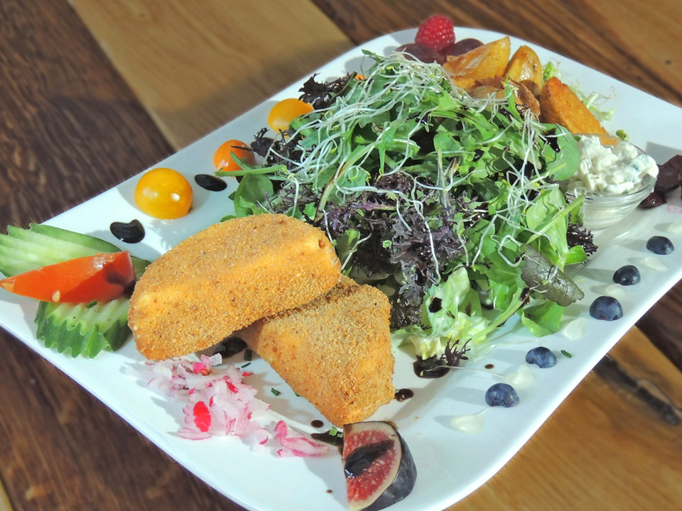 Schnitzels Salat Nico - angerichteter Salatteller mit Schafskäse, Kartoffelecken, Sour Cream Dip und Baguette